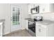 Bright kitchen with stainless steel appliances, white cabinets, granite counters, and a door leading to the outside at 279 Canopy Dr, Graham, NC 27253