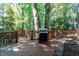 Inviting back deck with a grill, outdoor seating, and a beautiful wooded backdrop at 3005 Woodgreen Dr, Raleigh, NC 27607