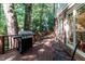 Inviting back deck with a grill, outdoor seating, and wooded backdrop at 3005 Woodgreen Dr, Raleigh, NC 27607