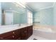 Bathroom featuring a spacious bathtub, large mirror, and decorative wallpaper at 3005 Woodgreen Dr, Raleigh, NC 27607