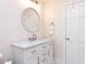 Bright bathroom featuring a white vanity with marble countertop and decorative round mirror at 3005 Woodgreen Dr, Raleigh, NC 27607