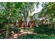 Exterior view from backyard showing the deck and brick siding and ample natural foliage surrounding the home at 3005 Woodgreen Dr, Raleigh, NC 27607