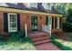 Inviting brick home entrance with black door and manicured landscaping at 3005 Woodgreen Dr, Raleigh, NC 27607