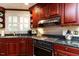 Close-up on a kitchen featuring wood cabinets, granite countertops, and modern appliances at 3005 Woodgreen Dr, Raleigh, NC 27607