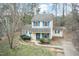 Two-story home with a blue door and blue window shutters surrounded by sparse vegetation at 3323 Nantuckett Ave, Durham, NC 27703