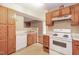 Cozy kitchen with white appliances, wood cabinets, and easy access to other living spaces at 3323 Nantuckett Ave, Durham, NC 27703