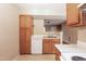 Classic kitchen design with wooden cabinetry, double bowl sink, and white dishwasher appliance at 3323 Nantuckett Ave, Durham, NC 27703