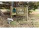 A sign saying Hidden Hollow with an oak tree design, situated in a quiet and natural setting at 3323 Nantuckett Ave, Durham, NC 27703