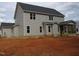 Two-story home's backyard with a screened in porch with wood beams, set in an unfinished yard at 358 Coats Ridge Dr, Benson, NC 27504