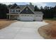 Charming two-story home featuring a wide driveway and a three-car garage, set against a backdrop of lush trees at 358 Coats Ridge Dr, Benson, NC 27504