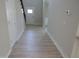 Inviting hallway with light wood-look flooring leading to a white front door with sidelights at 358 Coats Ridge Dr, Benson, NC 27504