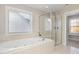 Bright bathroom with a soaking tub, glass shower, and window with blinds at 3910 Wedonia Dr, Cary, NC 27519