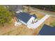 Overhead view of a new home featuring a dark roof, light exterior, and a concrete driveway and patio at 4017 Mebane Oaks Rd, Mebane, NC 27302