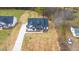 Beautiful new home with a black roof and white exterior, complemented by a spacious yard and a paved driveway at 4017 Mebane Oaks Rd, Mebane, NC 27302