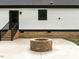 Inviting backyard featuring a stone fire pit, concrete patio, and access to the home, perfect for outdoor entertaining at 4017 Mebane Oaks Rd, Mebane, NC 27302