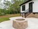 Backyard patio featuring a charming brick fire pit and providing a cozy outdoor gathering space at 4017 Mebane Oaks Rd, Mebane, NC 27302
