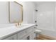 Bathroom with gold trimmed mirror, white counter top and cabinets, with a bath tub at 4017 Mebane Oaks Rd, Mebane, NC 27302