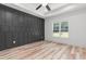 Bedroom featuring a decorative black accent wall, tray ceiling, and view of the yard at 4017 Mebane Oaks Rd, Mebane, NC 27302