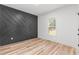 Bedroom featuring a designer accent wall, bright window, and light wood-look flooring at 4017 Mebane Oaks Rd, Mebane, NC 27302