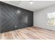 Bedroom featuring a designer accent wall, bright window, and light wood-look flooring at 4017 Mebane Oaks Rd, Mebane, NC 27302