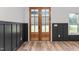 Foyer with wood-trimmed glass paneled doors and black wainscoting that create a welcoming entrance at 4017 Mebane Oaks Rd, Mebane, NC 27302