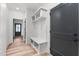 Functional mudroom with built-in bench, storage shelves, and wood-look floors at 4017 Mebane Oaks Rd, Mebane, NC 27302