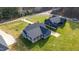 Overhead shot of a gray home with a covered front porch and long driveway, on a large lot with green grass at 4037 Mebane Oaks Rd, Mebane, NC 27302