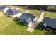 An aerial perspective features a gray home with a covered porch, complemented by green lawns and surrounding trees at 4037 Mebane Oaks Rd, Mebane, NC 27302