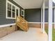 An outdoor covered porch with wooden stairs offers a peaceful transition from indoor to outdoor living at 4037 Mebane Oaks Rd, Mebane, NC 27302