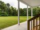 A covered back porch offers a peaceful outdoor living space and beautiful views of the lush green yard at 4037 Mebane Oaks Rd, Mebane, NC 27302