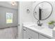 Bathroom with white vanity, black fixtures, and round mirror at 4037 Mebane Oaks Rd, Mebane, NC 27302