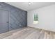 Bedroom with stylish accent wall, light wood floors, and a window that offers plenty of natural light at 4037 Mebane Oaks Rd, Mebane, NC 27302