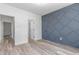 Spacious bedroom with stylish accent wall, light wood floors, and multiple door access at 4037 Mebane Oaks Rd, Mebane, NC 27302