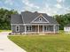 Charming exterior featuring a gray craftsman home with a welcoming covered porch and well-manicured lawn at 4037 Mebane Oaks Rd, Mebane, NC 27302