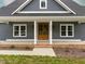 Close up of the front facade with beautiful double doors and craftsman style finishes on a gray home at 4037 Mebane Oaks Rd, Mebane, NC 27302