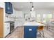 Well-lit kitchen featuring white cabinets, stainless steel appliances, and a center island at 4037 Mebane Oaks Rd, Mebane, NC 27302