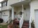 Inviting front porch features white pillars and railings, and steps leading up to the entrance door of a townhome at 4245 Toccopola St, Raleigh, NC 27604