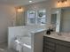This bathroom has a soaking tub, nice mirrors and vanity, plus a large window for natural light at 46 Shortstop Cir, Four Oaks, NC 27524