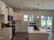 Spacious kitchen with white cabinets, stainless steel appliances, and a large island at 46 Shortstop Cir, Four Oaks, NC 27524