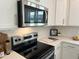 Modern kitchen with stainless steel appliances, white cabinets, and stylish backsplash at 46 Shortstop Cir, Four Oaks, NC 27524