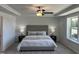 This main bedroom offers a tray ceiling, a ceiling fan, a large window and beautiful decor at 46 Shortstop Cir, Four Oaks, NC 27524