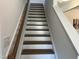 Staircase with white risers, wood treads, and a matching handrail at 46 Shortstop Cir, Four Oaks, NC 27524