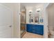 Bright bathroom features a blue double sink vanity, walk-in shower, and neutral tile flooring at 580 Long View Dr, Youngsville, NC 27596