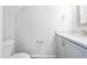 Well-lit half-bathroom features a single vanity, a toilet, and a large mirror at 6233 Pesta Ct, Raleigh, NC 27612