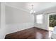Dining area with hardwood floors, wainscoting, chandelier, and glass sliding doors to the backyard at 6233 Pesta Ct, Raleigh, NC 27612