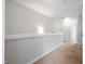 Second-floor hallway with neutral paint and carpet, showing access to additional rooms at 6233 Pesta Ct, Raleigh, NC 27612
