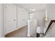 Upstairs hallway with carpet flooring and two closet doors, adjacent to the staircase at 6233 Pesta Ct, Raleigh, NC 27612
