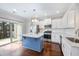 Spacious kitchen with stainless appliances, white cabinets, and a center island leading to the patio at 6233 Pesta Ct, Raleigh, NC 27612