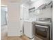 Bright laundry room with modern washer and dryer units and wire shelving at 6233 Pesta Ct, Raleigh, NC 27612