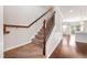 Carpeted staircase with dark wood and wrought iron handrail leading to the second floor of the home at 6233 Pesta Ct, Raleigh, NC 27612